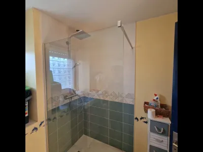 Douche à l’italienne avec carrelage bleu et paroi en verre