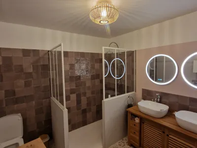 Salle de bain avec miroir rond et douche à l’italienne