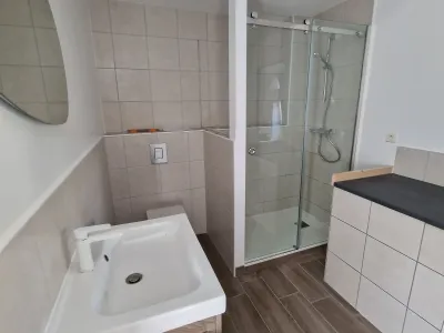 Salle de bain avec meuble vasque en bois et douche à l’italienne