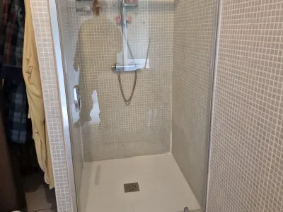 Douche avec carrelage beige et paroi vitrée