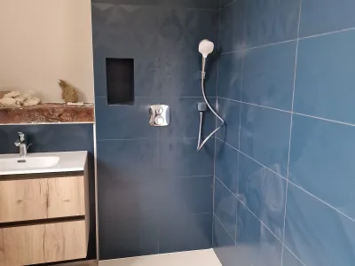 Douche à l’italienne avec carrelage bleu et robinetterie moderne