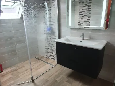 Salle de bain avec douche vitrée et lavabo suspendu