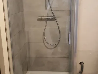 Douche à l’italienne avec paroi vitrée et robinetterie moderne