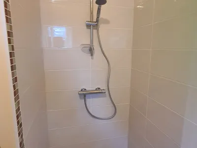 Douche moderne avec carrelage et douchette murale