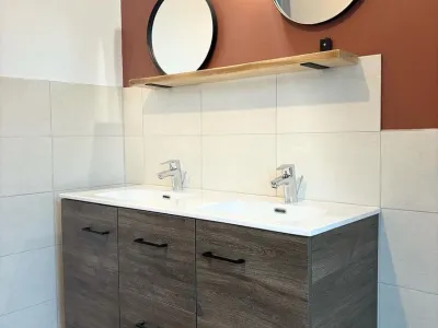 Salle de bain moderne avec double vasque et miroir rond lumineux