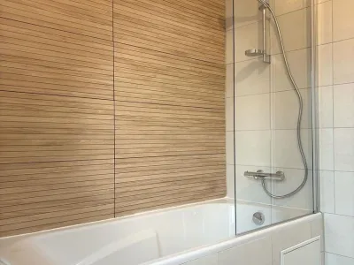 Salle de bain avec baignoire et douche à l’italienne en carrelage bois