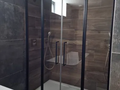 Douche à l’italienne avec paroi vitrée et robinetterie contemporaine